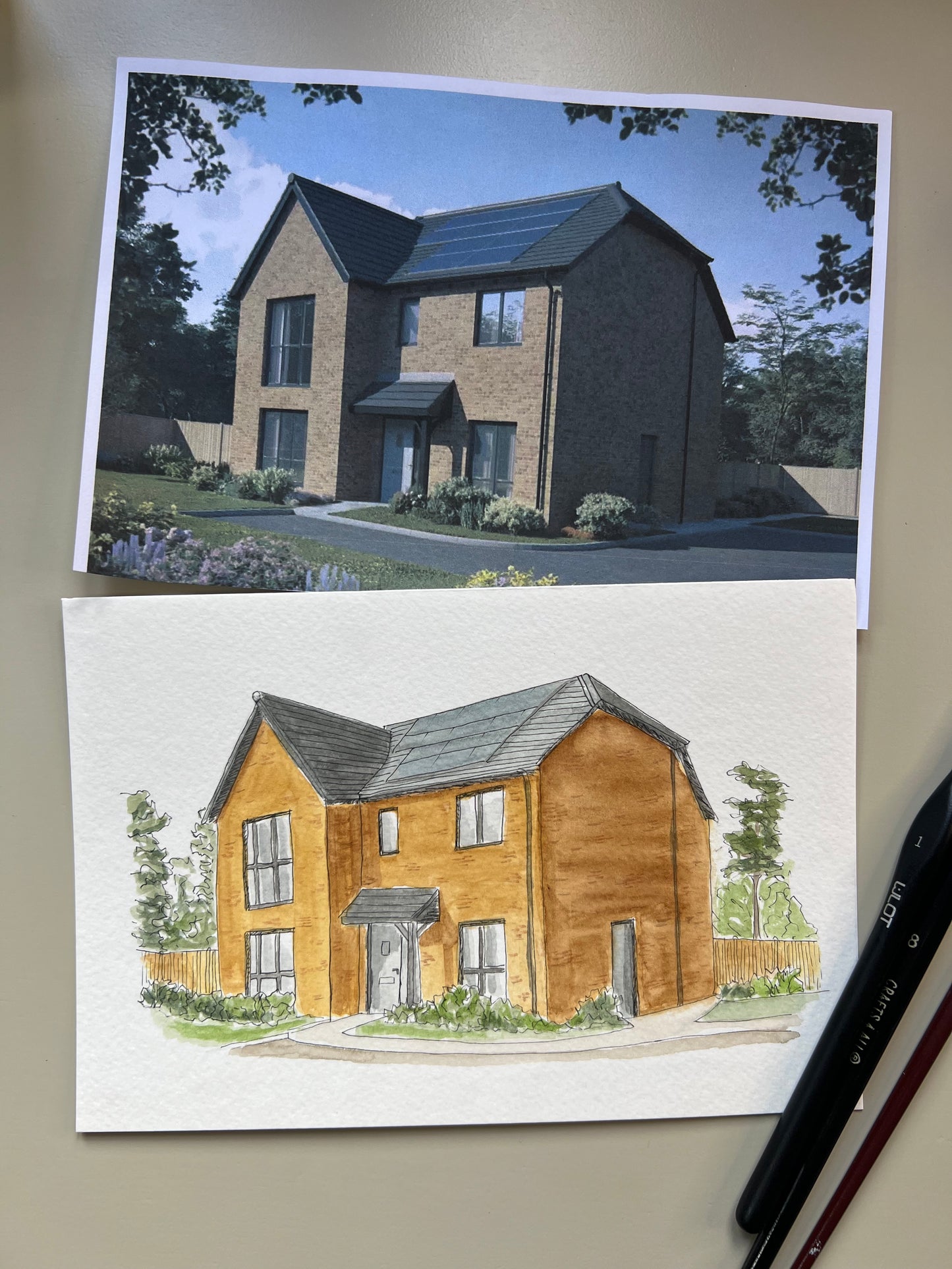 Artwork of a watercolour house portrait with paint tubes and original photo on paper in the background.