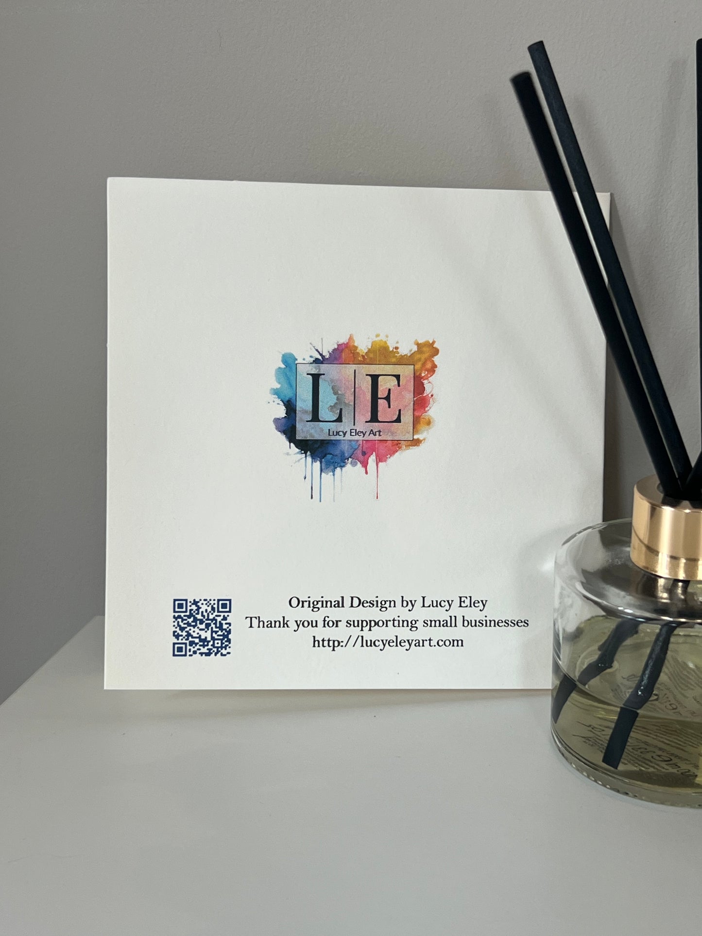 Rear of Handmade greeting card with colourful logo with a QR code and text on an ivory background