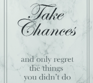 Close up of a print with the text 'Take chances and only regret the things you didn't do' on a grey marble background with a double border and white mount.