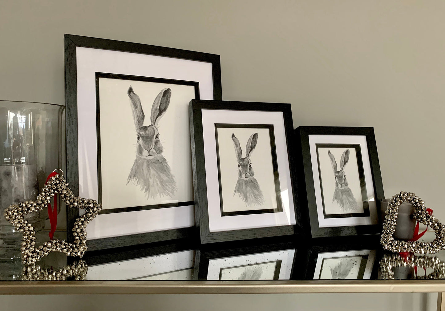 Set of 3 Watercolour hare in grey tones in a black wooden frame with double mount showing different sized frames.