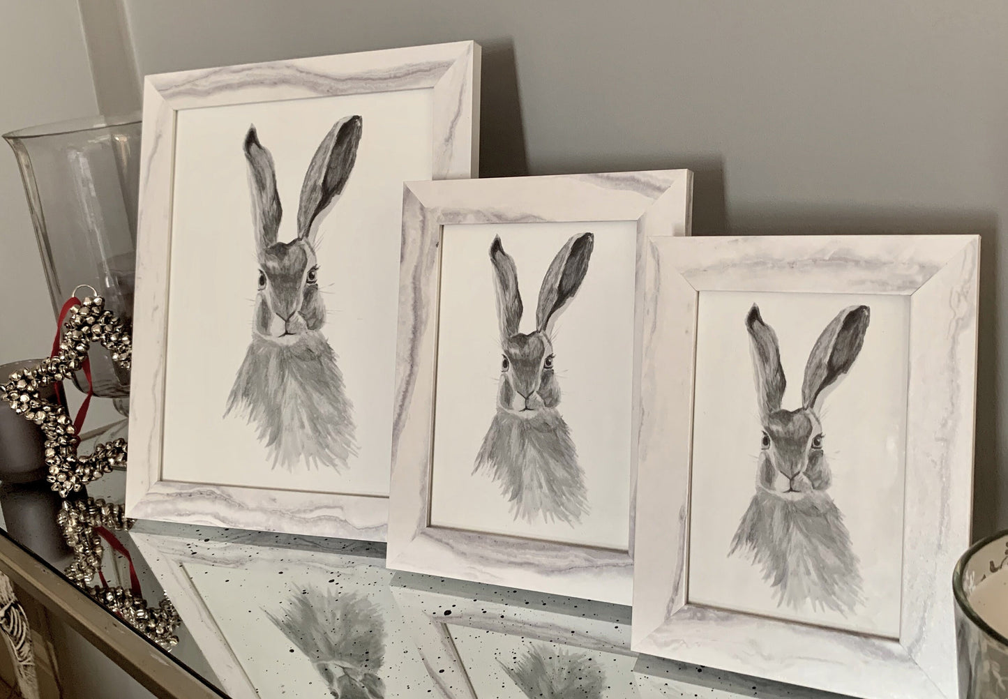 Watercolour hare in grey tones in a marble effect wooden frame.