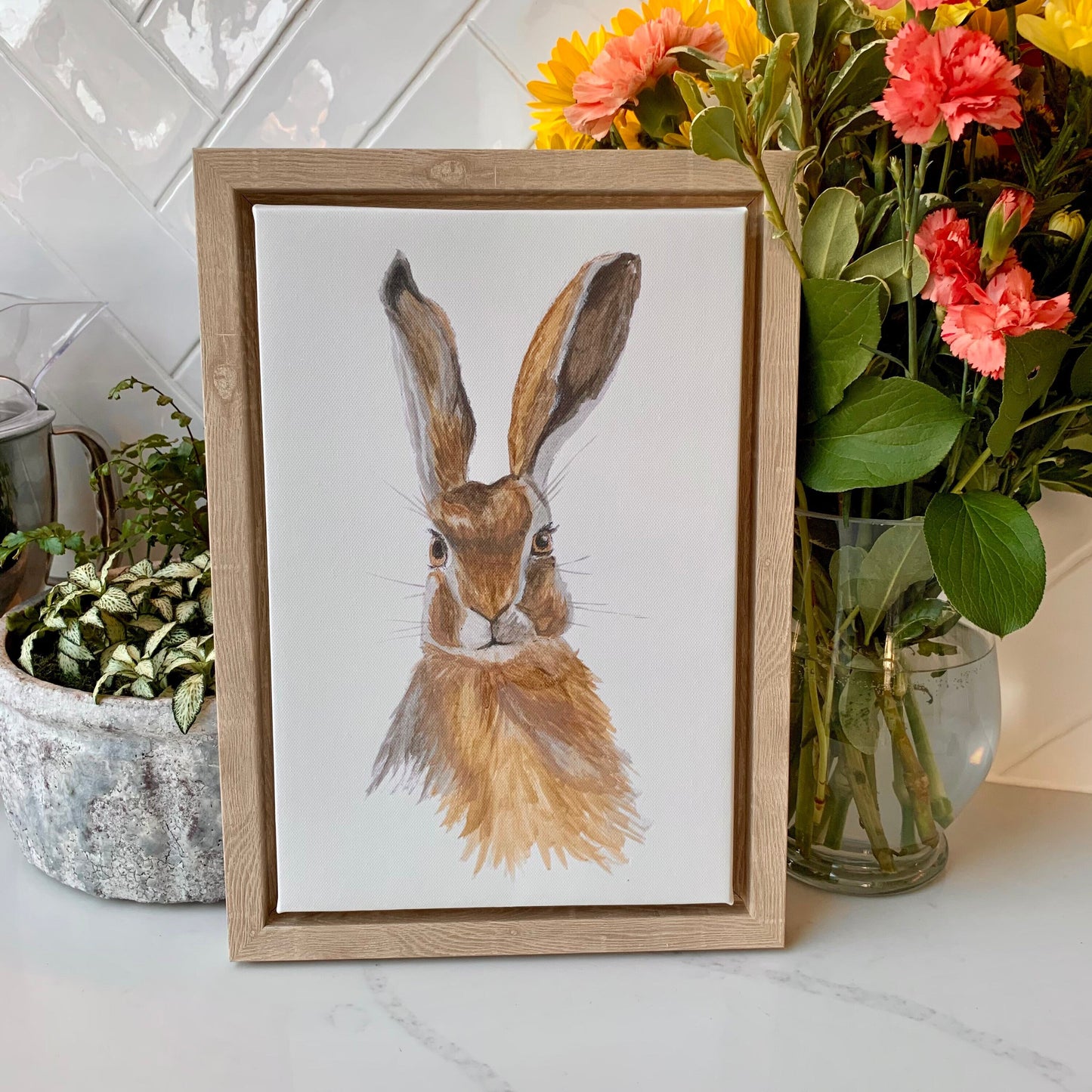 Watercolour hare in brown and grey tones on a canvas in a natural finish wooden frame.