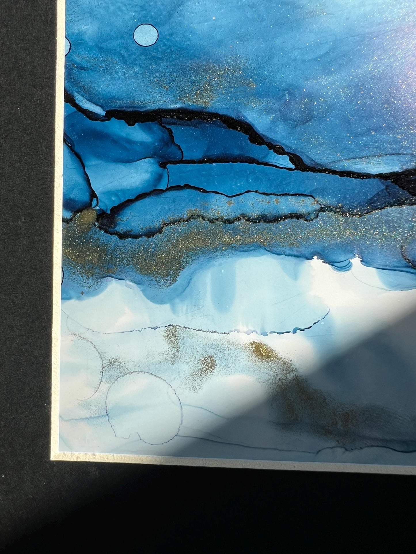 An A5 size contemporary ink painting featuring blue and metallic colors with gold shimmers, presented in a black frame.
