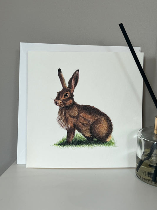 Handmade greeting card with artwork of a hare in warm browns and deep orange on an ivory background 