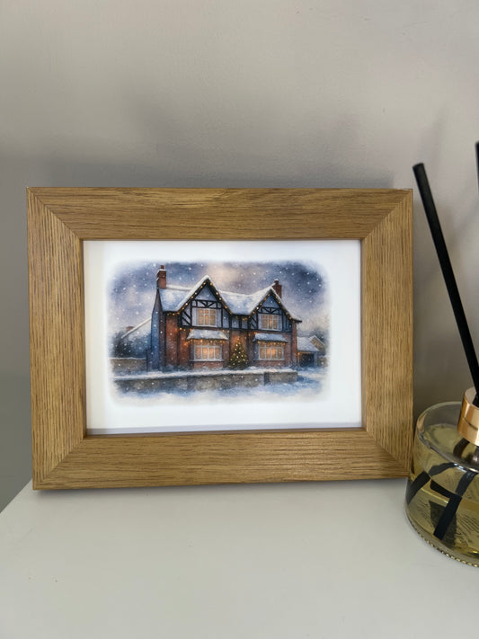Framed artwork of a tudor style period house portrait in a winter snowy scene  in digital watercolour in an oak finish frame. 