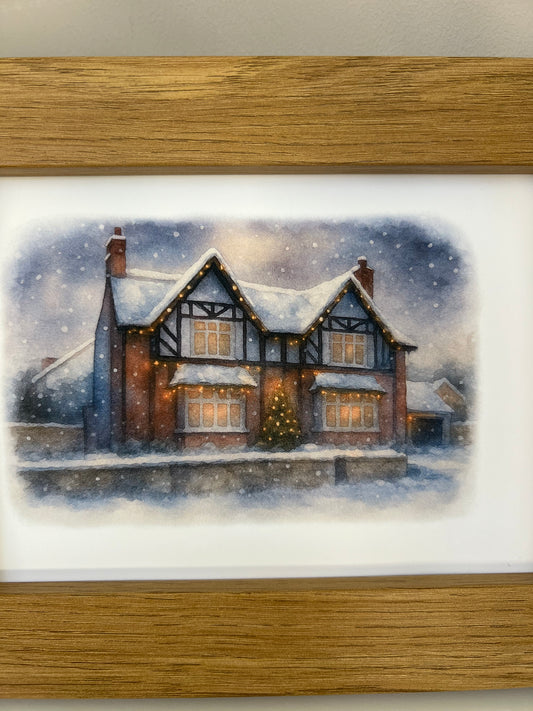 Close up of a framed artwork of a Tudor style period house portrait in a winter snowy scene  in digital watercolour in an oak finish frame.