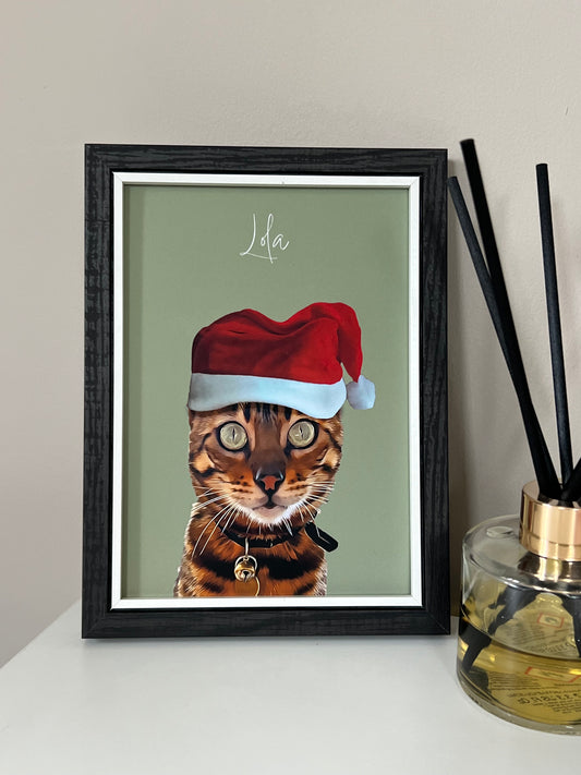 Framed artwork of a Bengal Cat wearing a Santa hat in a black frame on a beige wall.