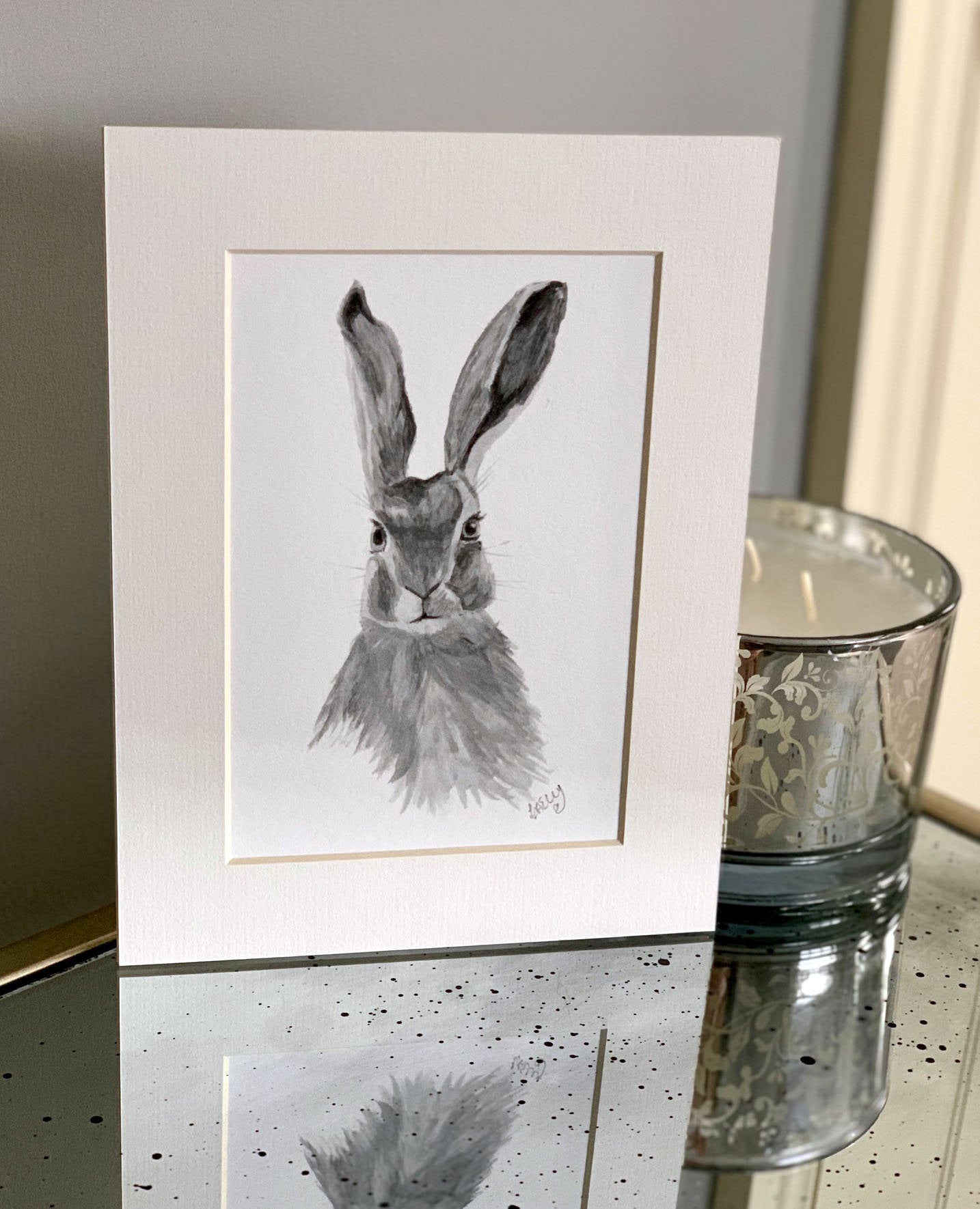 Watercolour hare in grey tones in a white mount.