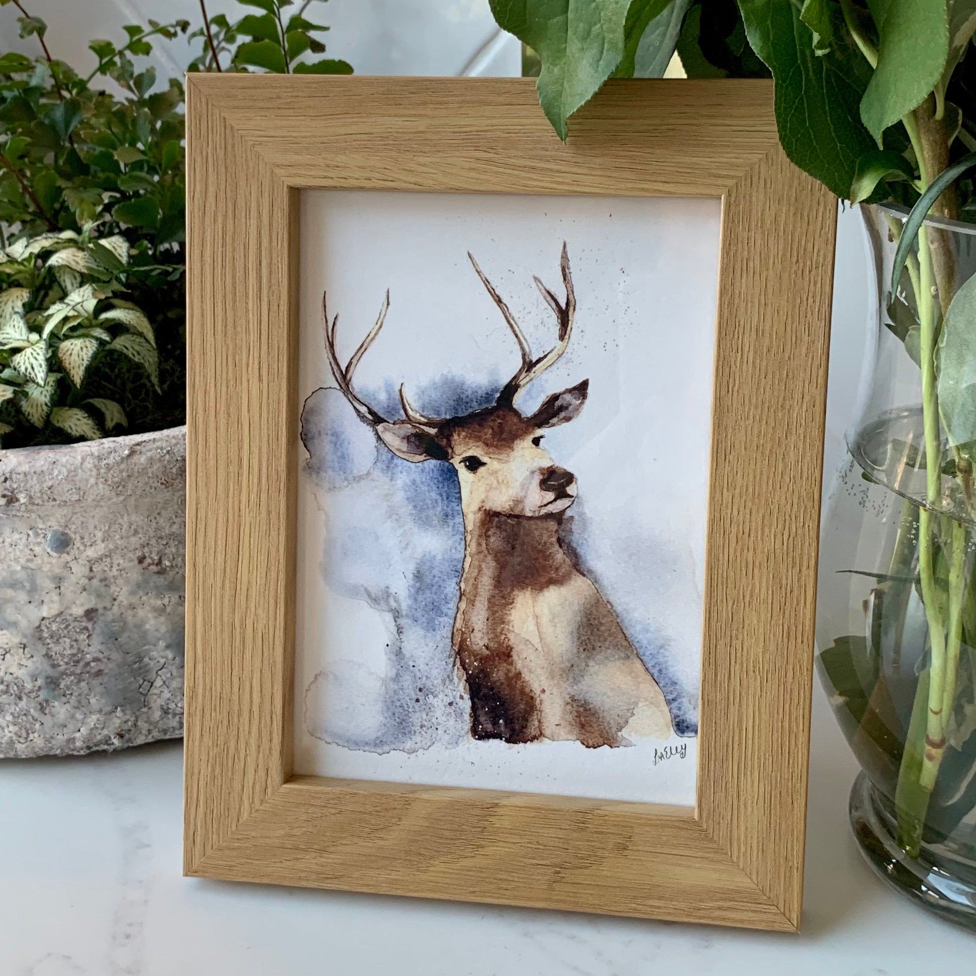 Watercolour stag in brown, grey and blue tones in a wooden frame. 