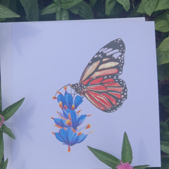 Video of a Monarch Butterfly illustration card with gold glitter accents on a white card with flowers and leaves around