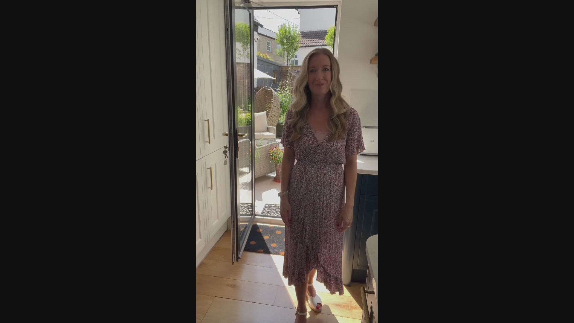 Video of artist with artwork of a custom watercolour German Shepherd Dog pet portrait and original photo in kitchen with garden in the background. 