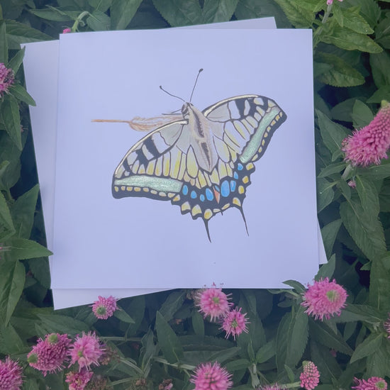 Swallowtail Butterfly illustration with green and gold glitter metallic finish on a white card with green foliage in the background.